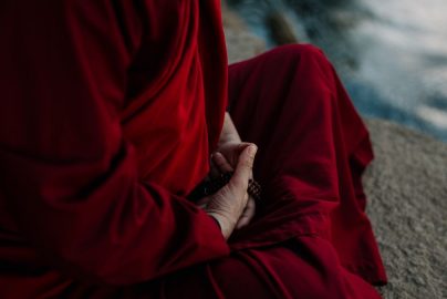 A monk in traditional robe holding prayer beads, embodying spirituality and tranquility.