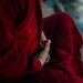 A monk in traditional robe holding prayer beads, embodying spirituality and tranquility.